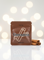 Cinnamon-flavored product package with cinnamon sticks on a reflective surface and blurred lights background